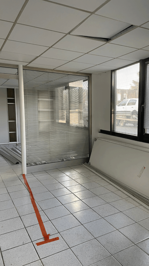 Une salle avec des cloisons, un faux plafond ec